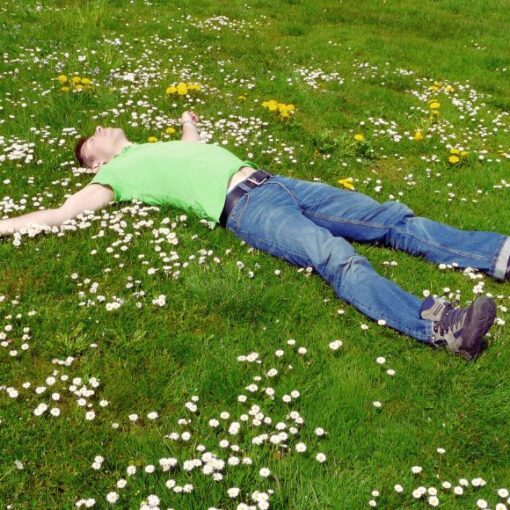 man-lying-on-grass-grounding